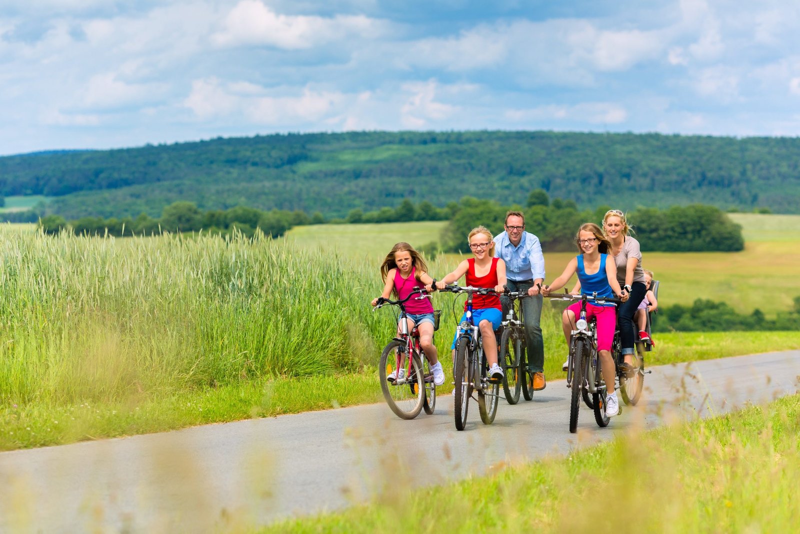 Lf routes DuitsEngels Fietsende familie in glooiend landschap LR